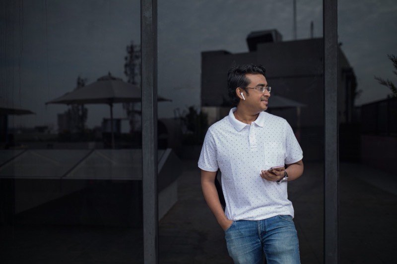 Homme avec écouteurs sans fil tenant son smartphone